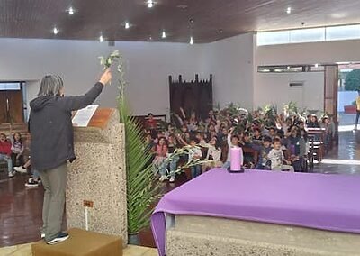 El viernes 30 de marzo vivimos la bendición de los ramos en la capilla de nuestro colegio. Así comenzamos Semana Santa, con la memoria de la entrada triunfante de Jesús a Jerusalem. Niñas, niños y jóvenes fueron llegando por niveles; primero el inicial, luego el intermedio y finalizamos con el ciclo avanzado, quienes iban ingresando cantando alegremente junto al coro el Hosana, que es tan característico del Domingo de Ramos. Luego veían un video con el relato de Jesús entrando en medio de una gran multitud en Jerusalem luego de haber estado en el monte Tabor orando. Muchos se preguntaban; “¿Quién es este?”, mientras que otros lo reconocían como el hijo de Dios, el que ha de venir, el que se profetizó por tanto tiempo. Finalmente se bendijeron los ramos que permanecen en nuestras casas hasta el inicio de la Cuaresma siguiente, pues se queman y se transforman en la ceniza que protagoniza el Miércoles de Ceniza. Fue una hermosa y animada jornada de fiesta e inicio de esta nueva Semana Santa.